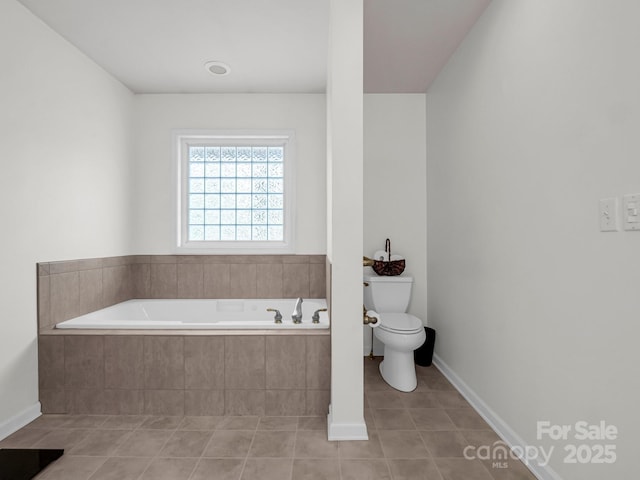 bathroom featuring toilet, tile patterned floors, and tiled bath