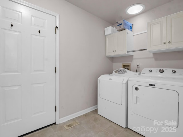 washroom with cabinets, washer and dryer, and light tile patterned floors