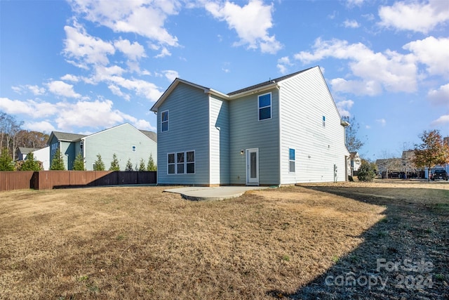 rear view of property with a yard and a patio