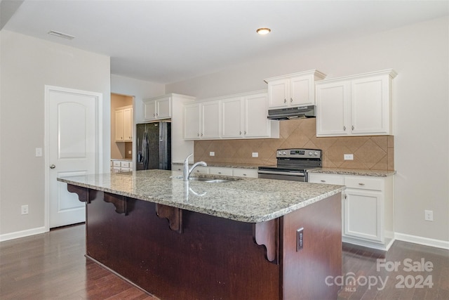 kitchen with stainless steel range with electric stovetop, a kitchen island with sink, black fridge, sink, and dark hardwood / wood-style flooring