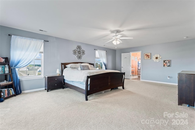 carpeted bedroom featuring connected bathroom and ceiling fan