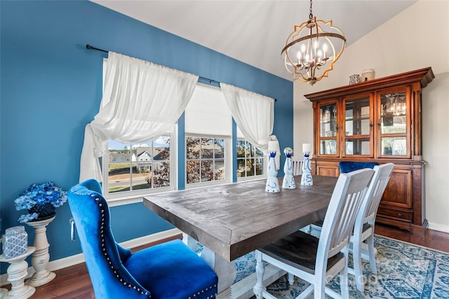 dining room featuring lofted ceiling, dark wood-type flooring, and a notable chandelier