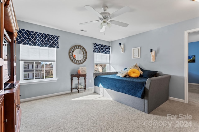 carpeted bedroom with ceiling fan and multiple windows