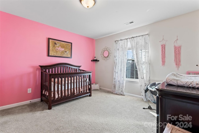 carpeted bedroom featuring a crib