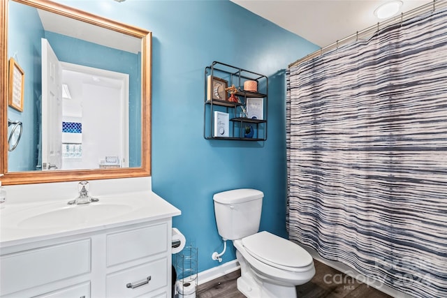 bathroom featuring hardwood / wood-style flooring, vanity, toilet, and walk in shower