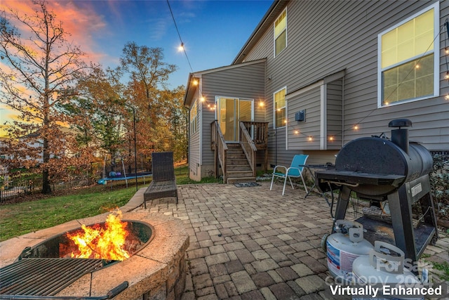 patio terrace at dusk featuring grilling area and a trampoline