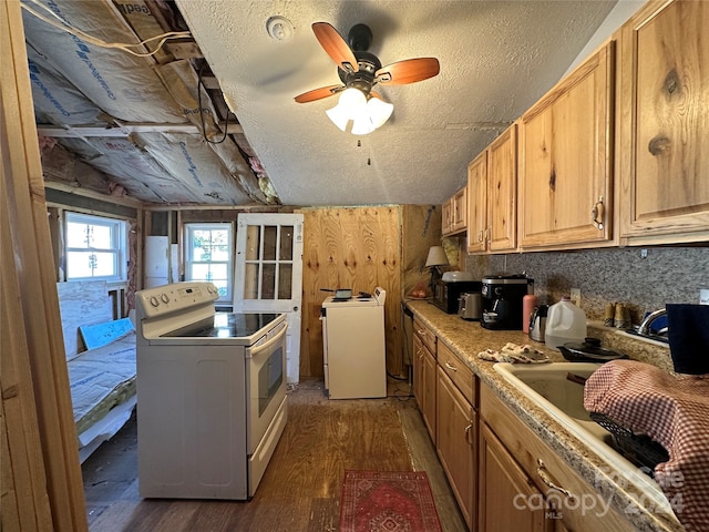 kitchen with white electric range, dark hardwood / wood-style flooring, wood walls, a textured ceiling, and washer / dryer