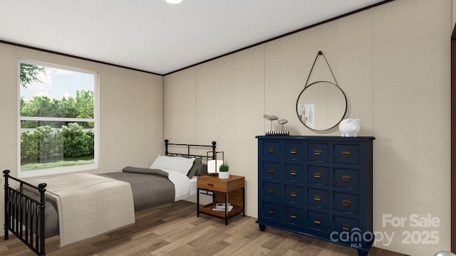 bedroom with light wood-type flooring and crown molding