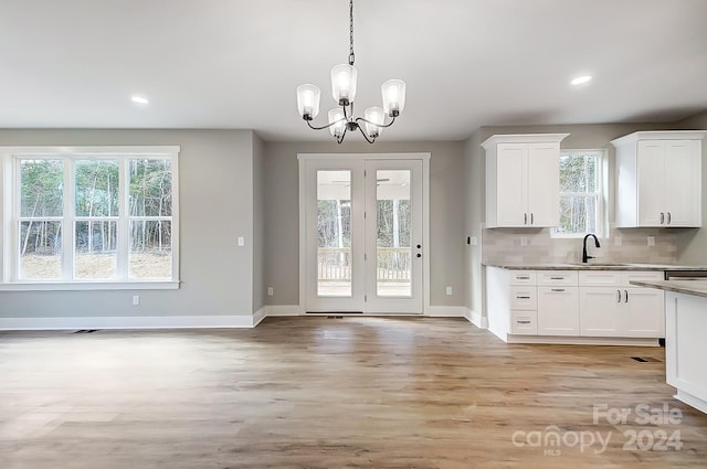 kitchen with light hardwood / wood-style floors, white cabinetry, and hanging light fixtures