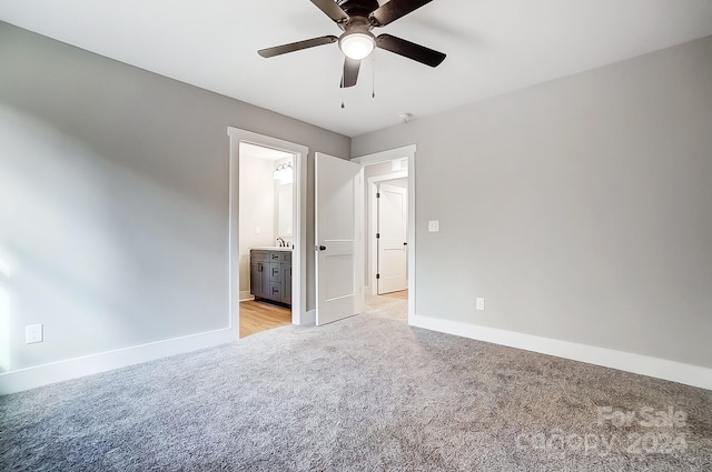 unfurnished bedroom with sink, ceiling fan, light colored carpet, and ensuite bathroom