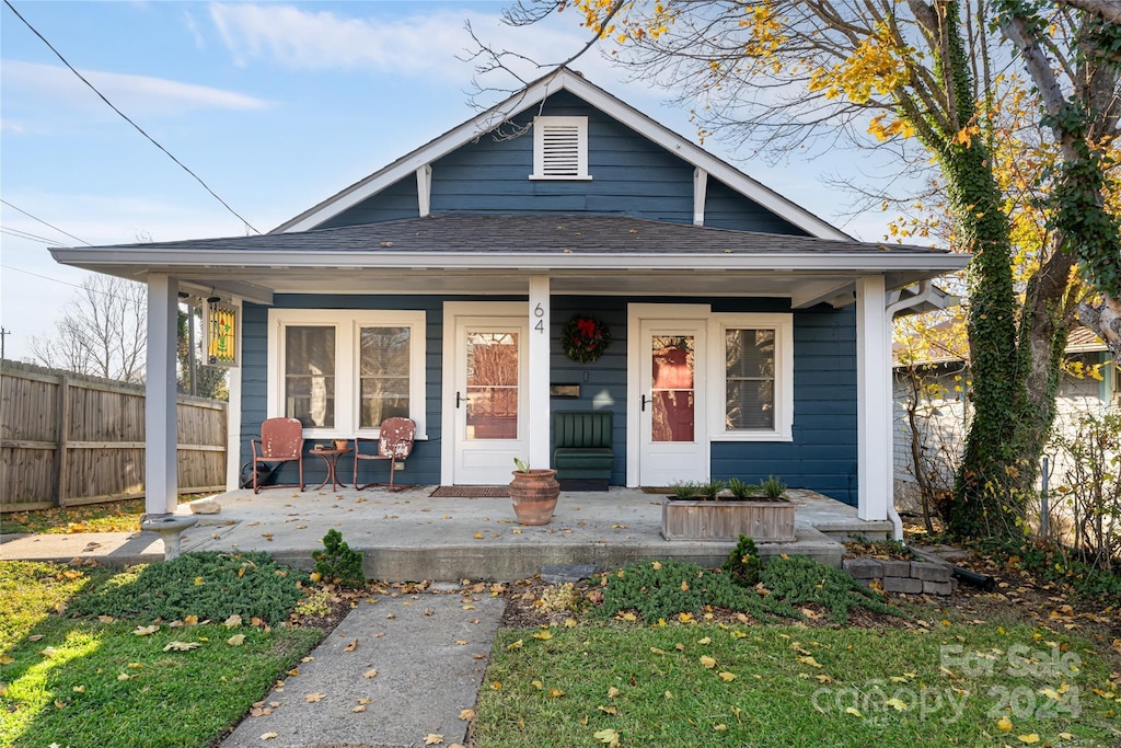 bungalow-style home with a front lawn and covered porch