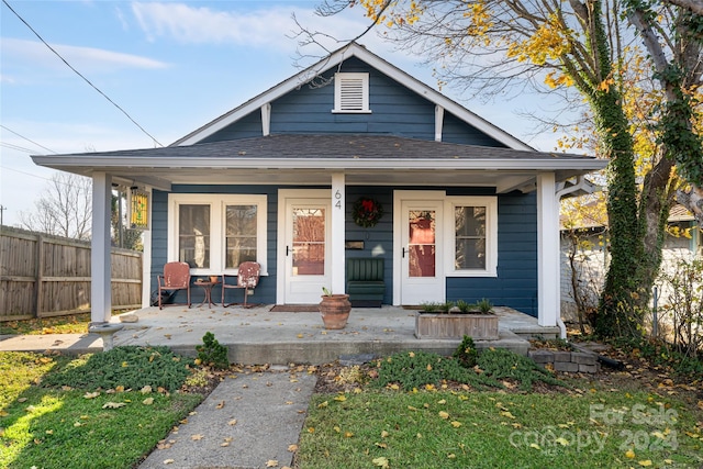 bungalow-style home with a front lawn and covered porch