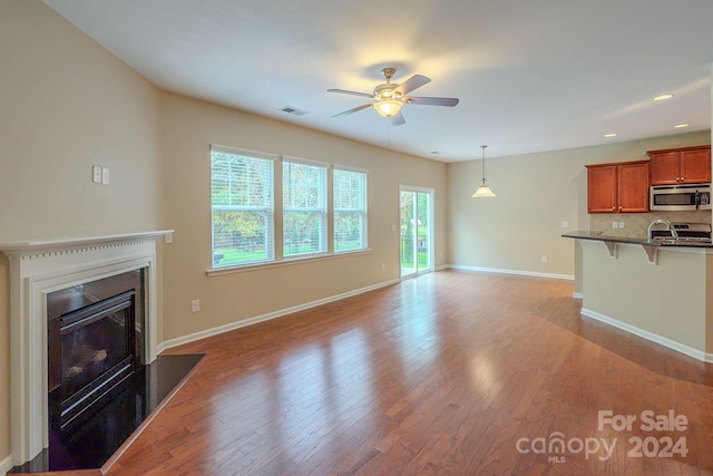 unfurnished living room featuring ceiling fan and light wood-type flooring