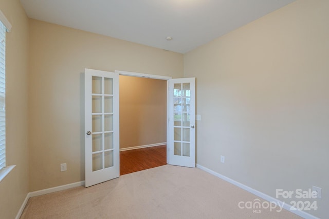 carpeted spare room with french doors