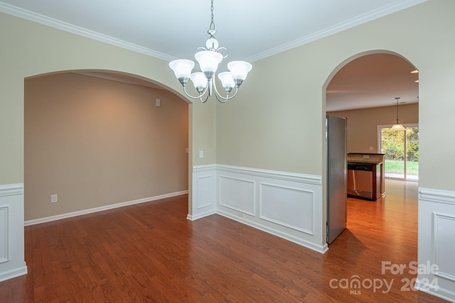 unfurnished room featuring a chandelier, wood-type flooring, and ornamental molding