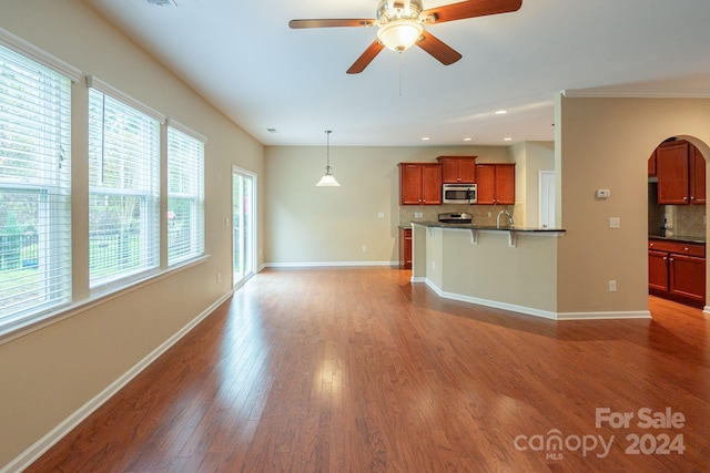 unfurnished living room featuring hardwood / wood-style floors and ceiling fan