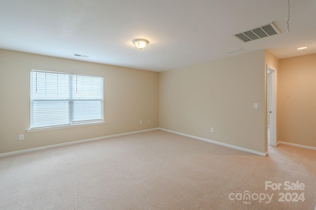 unfurnished room featuring light colored carpet