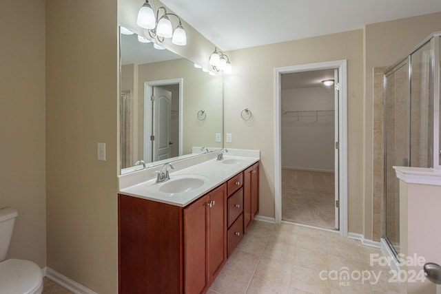 bathroom featuring tile patterned flooring, vanity, an enclosed shower, and toilet