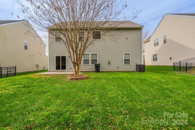 rear view of house featuring a yard, a patio, and central AC unit