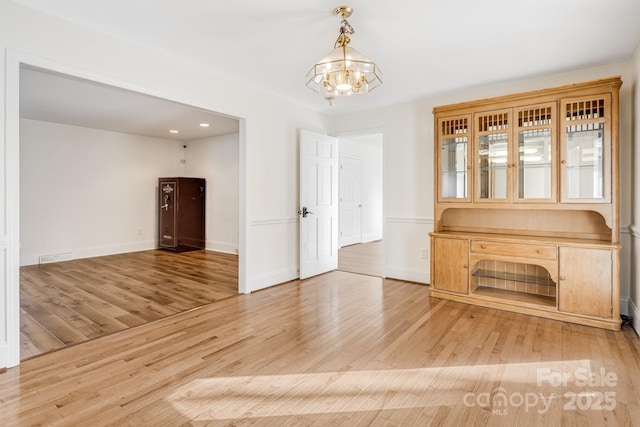 unfurnished room featuring a chandelier and hardwood / wood-style floors