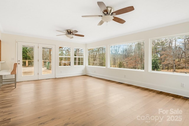 unfurnished sunroom with ceiling fan