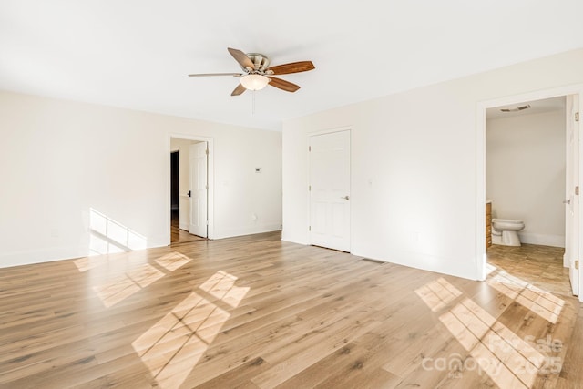 unfurnished bedroom with ensuite bath, ceiling fan, a closet, and light wood-type flooring