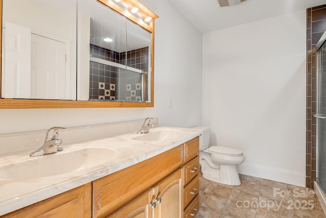 bathroom with vanity, toilet, and a shower with door