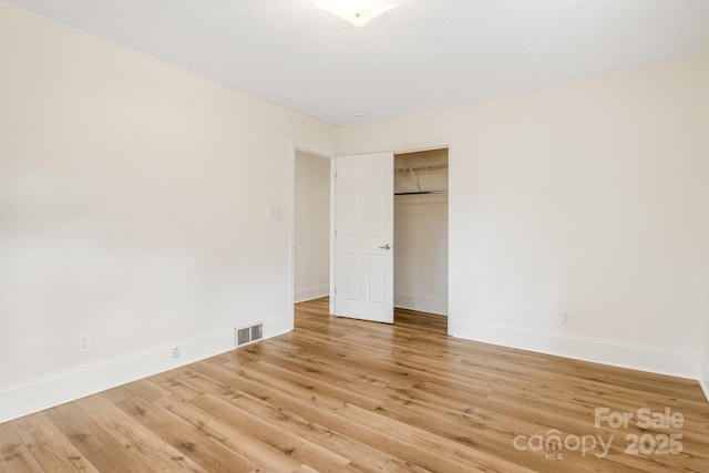 unfurnished bedroom featuring hardwood / wood-style floors and a closet