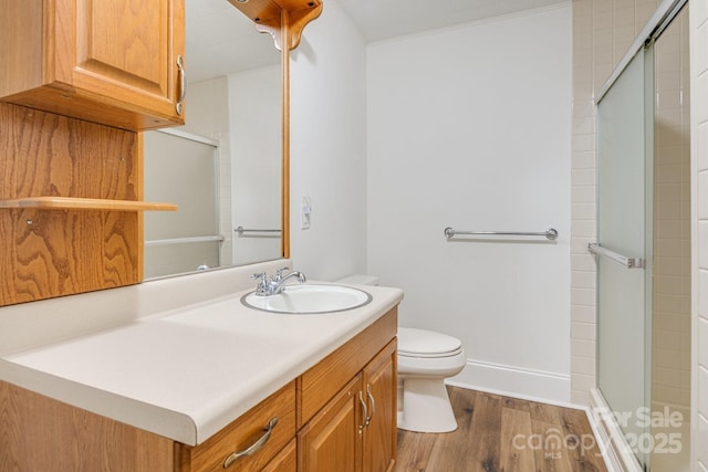 bathroom featuring hardwood / wood-style floors, toilet, an enclosed shower, and vanity