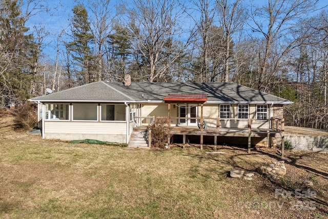 back of property featuring a wooden deck, a sunroom, and a yard