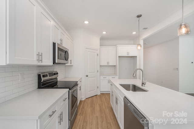 kitchen featuring white cabinets, appliances with stainless steel finishes, pendant lighting, and sink