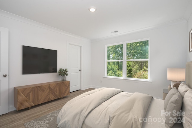 bedroom featuring crown molding and wood-type flooring