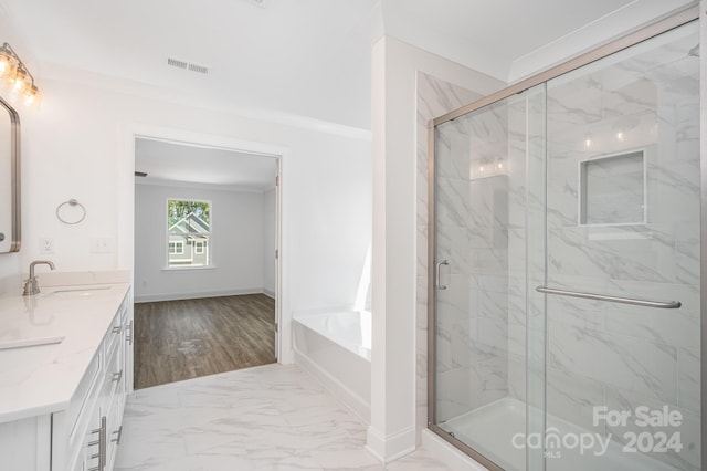 bathroom featuring plus walk in shower, vanity, hardwood / wood-style flooring, and ornamental molding