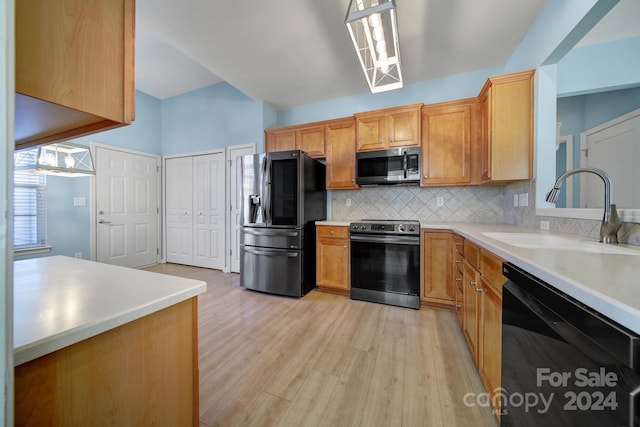 kitchen featuring backsplash, sink, light hardwood / wood-style floors, and appliances with stainless steel finishes