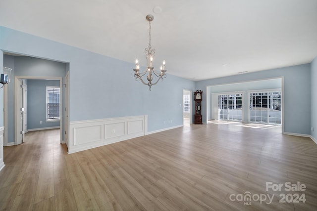 interior space featuring light hardwood / wood-style flooring, a healthy amount of sunlight, and a notable chandelier