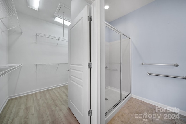 bathroom with hardwood / wood-style floors and a shower with shower door