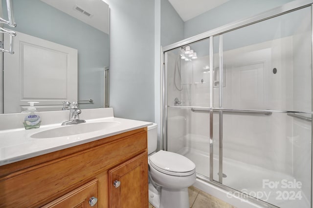 bathroom with toilet, vanity, tile patterned floors, and walk in shower