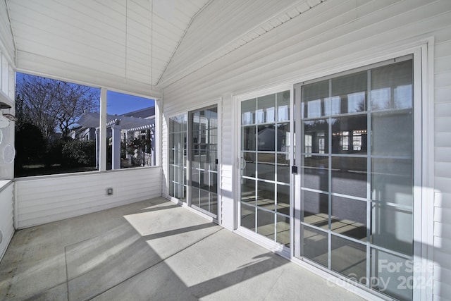 unfurnished sunroom featuring vaulted ceiling