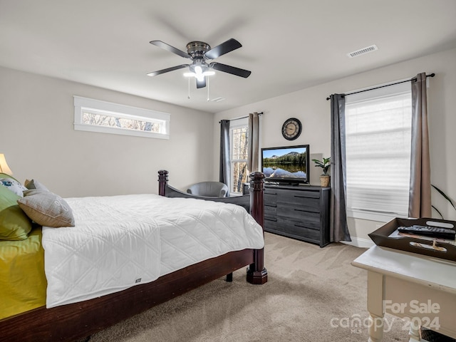 bedroom featuring light carpet, multiple windows, and ceiling fan