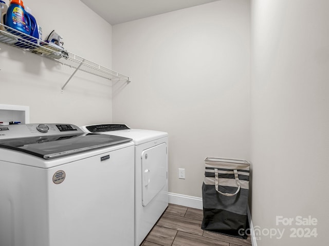 clothes washing area with light wood-type flooring and washing machine and clothes dryer