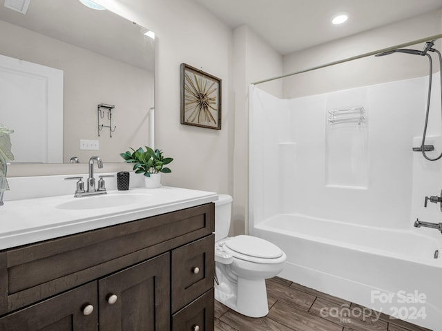 full bathroom featuring hardwood / wood-style floors, vanity, shower / bathtub combination, and toilet