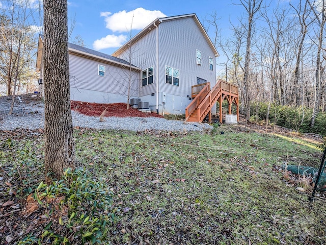 back of property with a wooden deck and central AC