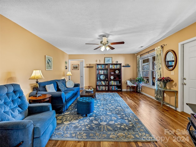 living room with ceiling fan, hardwood / wood-style floors, and a textured ceiling