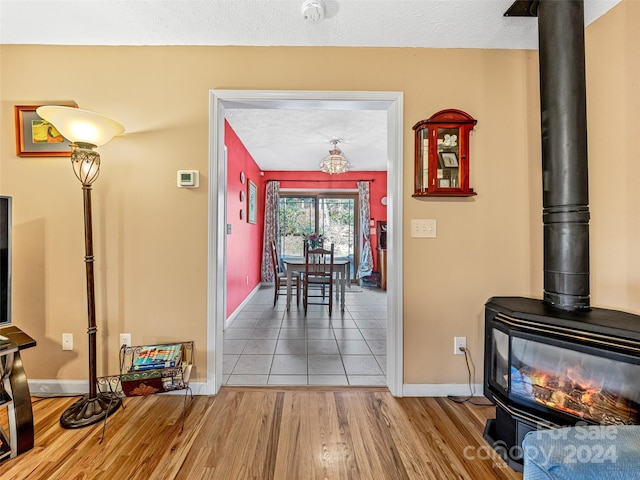 hallway with a textured ceiling and light hardwood / wood-style flooring