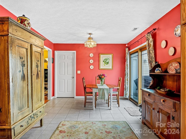 dining area with light tile patterned flooring and a textured ceiling