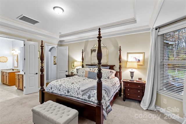 carpeted bedroom featuring a raised ceiling, crown molding, and connected bathroom