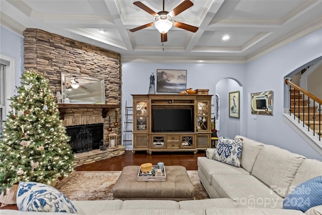 living room featuring beamed ceiling, wood-type flooring, a stone fireplace, and coffered ceiling