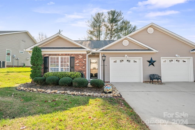 ranch-style home with a garage, a front yard, and central AC