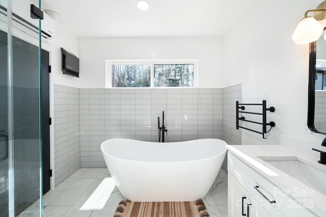 bathroom with vanity, independent shower and bath, and tile walls