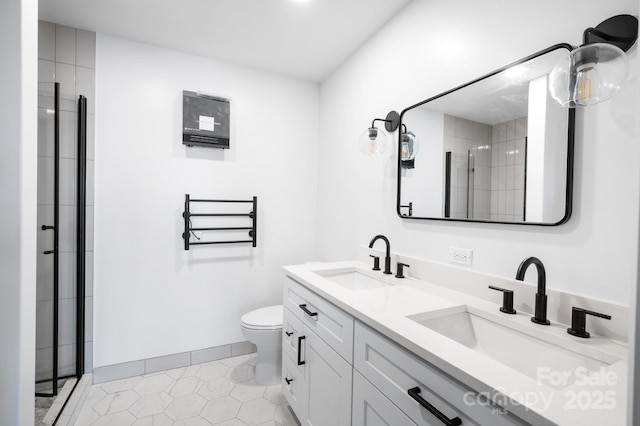 bathroom with tile patterned floors, a shower with door, vanity, and toilet